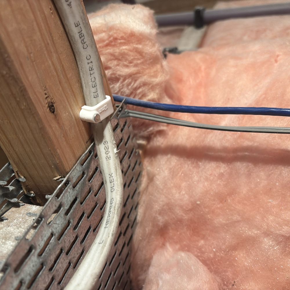 Electrical cable touching metal framing, which raises the risk of shock, found during a pre-handover inspection in Wollert